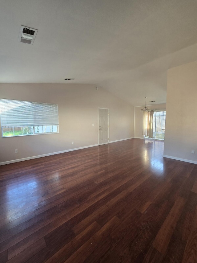 spare room with dark wood-type flooring, baseboards, visible vents, and vaulted ceiling