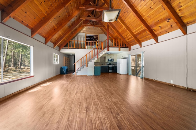 unfurnished living room featuring wood finished floors, beam ceiling, and wood ceiling