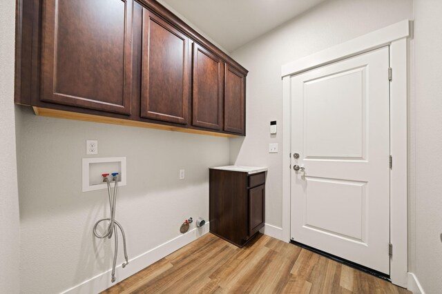4461 Risstay Way, Shasta Lake, CA 96019 - laundry room with baseboards, hookup for a washing machine, light wood-style flooring, hookup for a gas dryer, and cabinet space