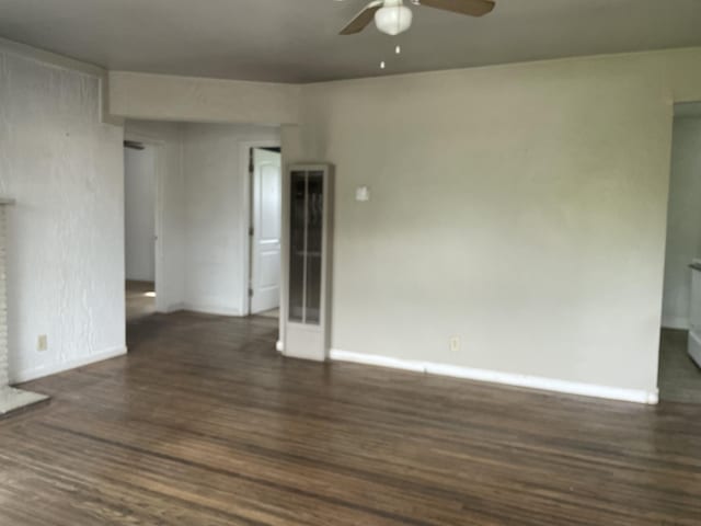empty room featuring baseboards, wood finished floors, and ceiling fan