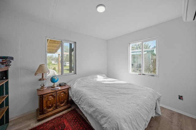 20292 Old Alturas Rd, Redding, CA 96003 - bedroom with baseboards, multiple windows, wood finished floors, and a wall mounted air conditioner