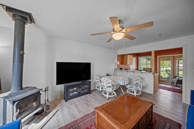 20292 Old Alturas Rd, Redding, CA 96003 - living area with a wood stove, ceiling fan, wood finished floors, and baseboards