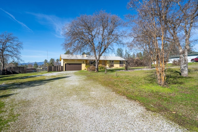 1200 Lema Rd, Redding, CA 96003 - ranch-style house featuring stucco siding, driveway, fence, a front yard, and a garage