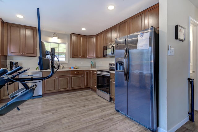 kitchen featuring light wood finished floors, baseboards, light countertops, recessed lighting, and stainless steel appliances