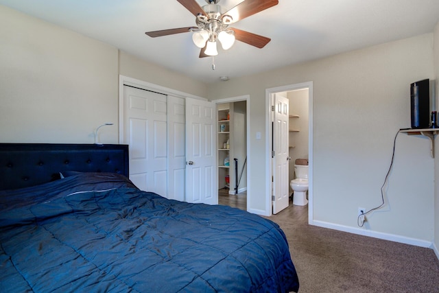carpeted bedroom with a closet, a ceiling fan, ensuite bath, and baseboards