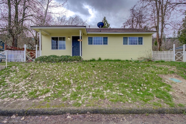 view of front of house featuring a front lawn and fence