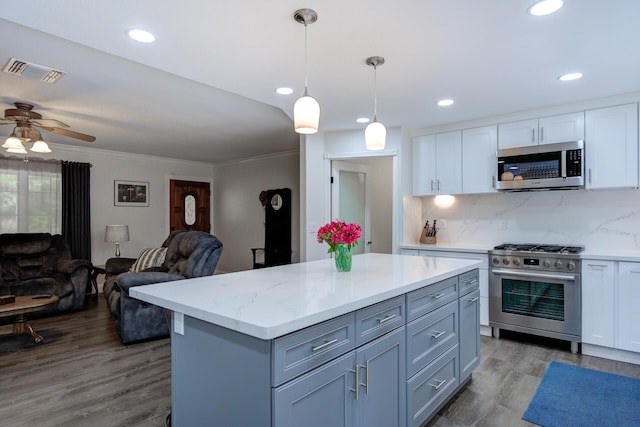 kitchen with white cabinets, visible vents, appliances with stainless steel finishes, open floor plan, and backsplash