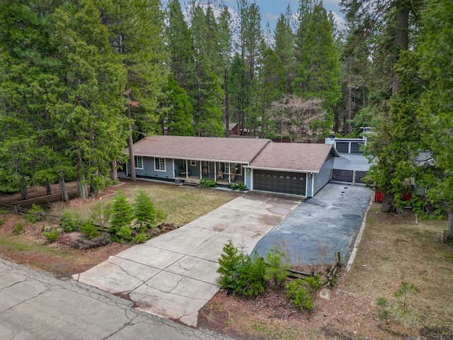 view of front facade featuring a porch, driveway, a front lawn, and an attached garage