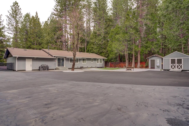 view of front of house featuring an outdoor structure, a shed, and fence