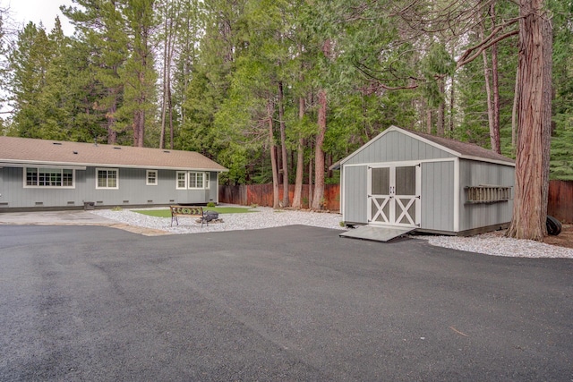 exterior space featuring an outbuilding, a shed, fence, crawl space, and a patio area