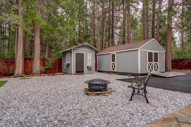 view of shed featuring an outdoor fire pit and fence