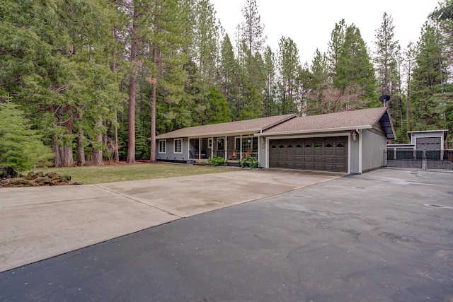 ranch-style house with a front lawn, a porch, a garage, and concrete driveway