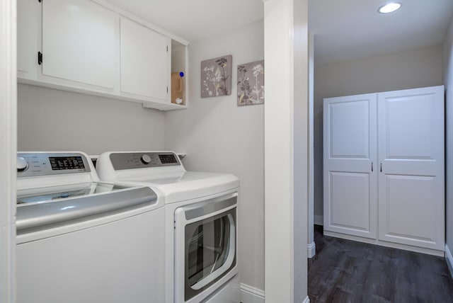 laundry room featuring washing machine and clothes dryer, cabinet space, baseboards, and dark wood-type flooring