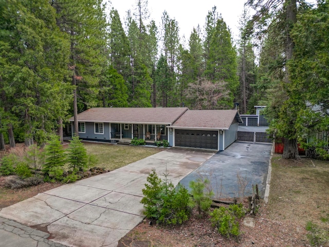 ranch-style house featuring covered porch, a front yard, driveway, and a garage