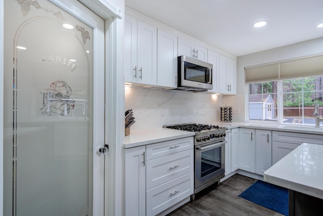 kitchen with white cabinets, light countertops, a sink, and stainless steel appliances
