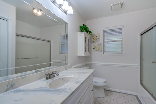 full bath featuring tile patterned floors, toilet, vanity, bath / shower combo with glass door, and visible vents