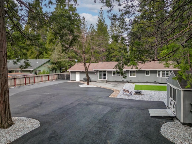 back of property featuring roof with shingles, an attached garage, fence, and a patio