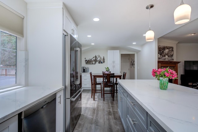 kitchen featuring pendant lighting, light stone countertops, wood finished floors, appliances with stainless steel finishes, and gray cabinetry