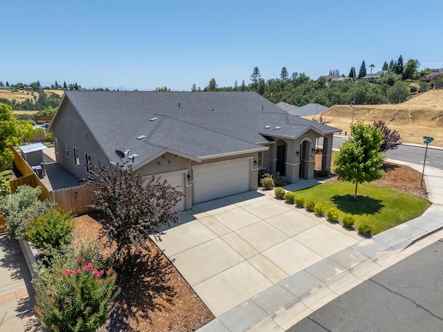 819 Bellagio Ter, Redding, CA 96003 - view of front facade with a garage, stucco siding, driveway, and roof with shingles