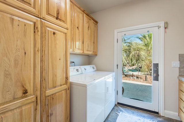 washroom featuring washing machine and clothes dryer, plenty of natural light, cabinet space, and baseboards