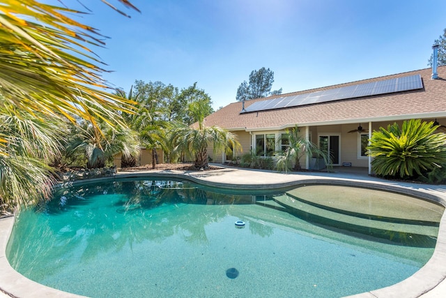 outdoor pool with ceiling fan and a patio