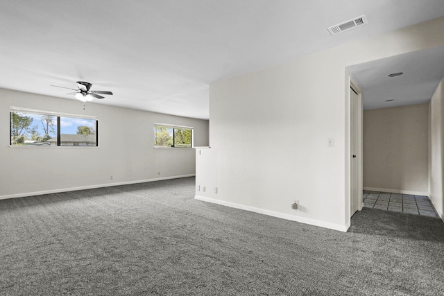 carpeted spare room with baseboards, visible vents, and a ceiling fan