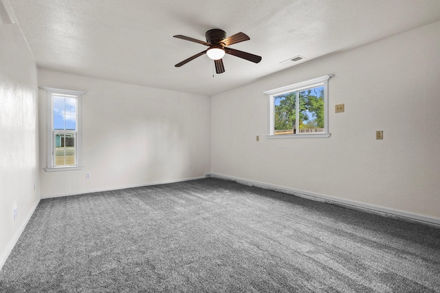 carpeted empty room featuring a ceiling fan, a textured ceiling, baseboards, and visible vents