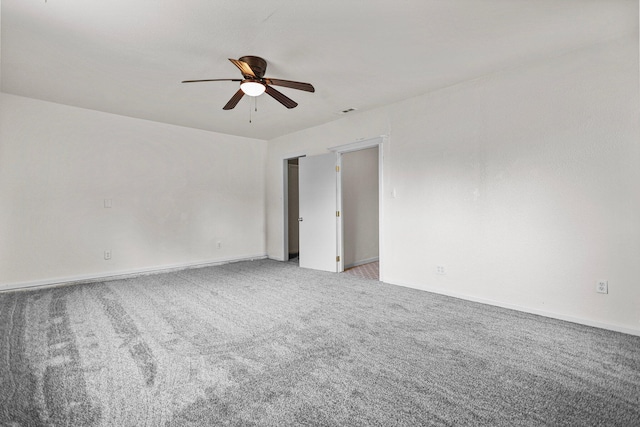 empty room featuring a ceiling fan, baseboards, light colored carpet, and visible vents