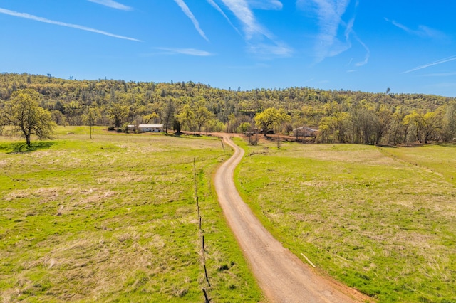 birds eye view of property featuring a wooded view and a rural view