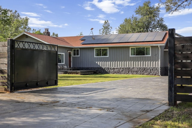 17622 China Gulch Dr, Anderson, CA 96007 - rear view of house with board and batten siding, solar panels, a yard, and a chimney