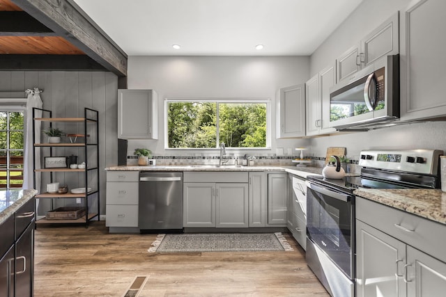 17622 China Gulch Dr, Anderson, CA 96007 - kitchen with a healthy amount of sunlight, stainless steel appliances, light wood-style floors, and gray cabinets