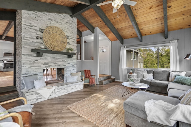 17622 China Gulch Dr, Anderson, CA 96007 - living room with wood ceiling, beam ceiling, ceiling fan, a stone fireplace, and wood finished floors