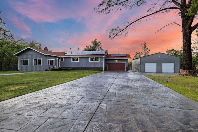 17622 China Gulch Dr, Anderson, CA 96007 - view of front of property featuring a detached garage, concrete driveway, solar panels, board and batten siding, and a lawn