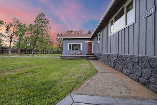 17622 China Gulch Dr, Anderson, CA 96007 - view of exterior entry with a lawn, a chimney, fence, and board and batten siding