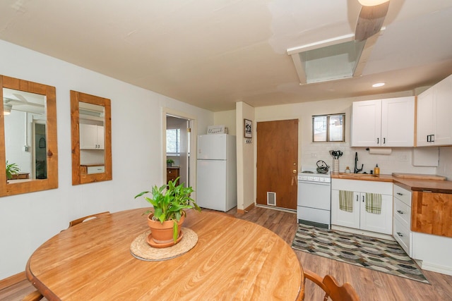 493 Main St, Weaverville, CA 96093 - kitchen with white appliances, wood finished floors, white cabinetry, backsplash, and butcher block countertops