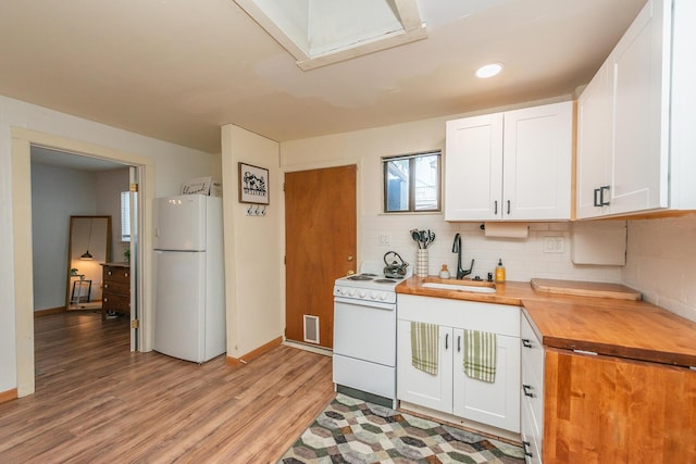 493 Main St, Weaverville, CA 96093 - kitchen featuring white appliances, wooden counters, light wood finished floors, white cabinets, and decorative backsplash