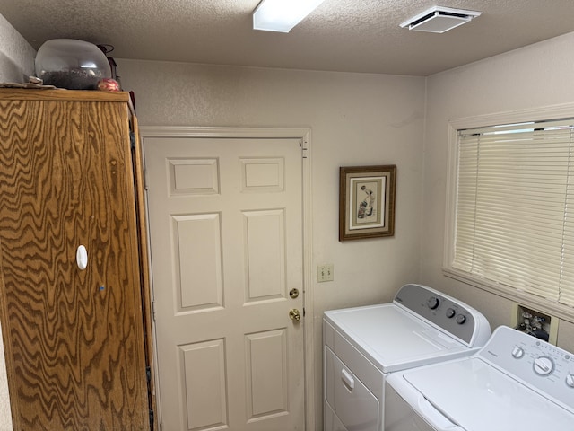 laundry room featuring independent washer and dryer, visible vents, laundry area, and a textured ceiling