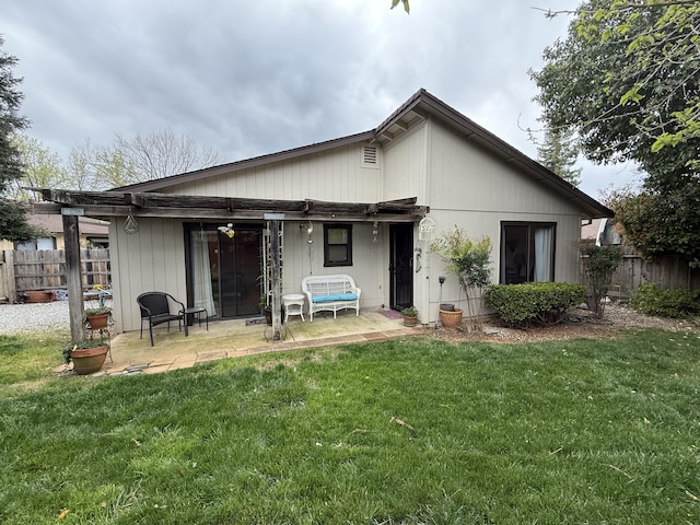 rear view of property with a yard, fence, and a patio area