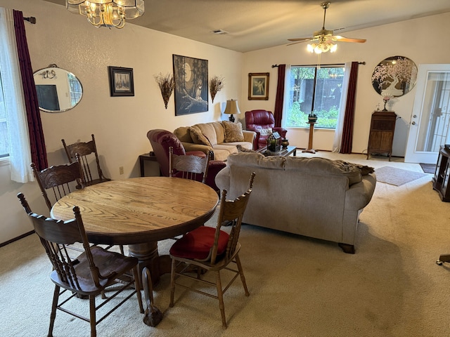 dining area with visible vents, vaulted ceiling, ceiling fan with notable chandelier, and light carpet