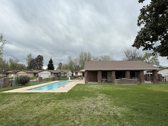 community pool with fence, a patio, and a yard