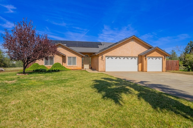 ranch-style house with concrete driveway, fence, an attached garage, a front lawn, and roof mounted solar panels