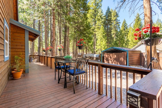 wooden terrace featuring an outbuilding and a storage unit