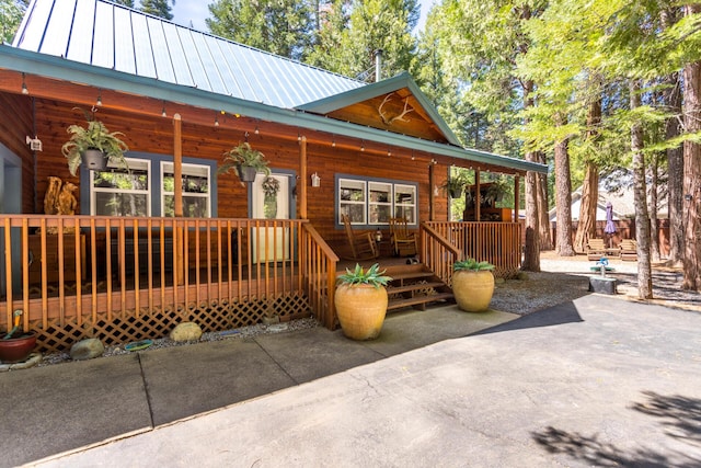 view of front of property with metal roof and a patio