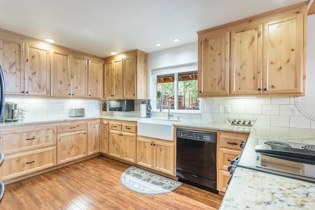 kitchen with a sink, wood finished floors, light brown cabinets, black dishwasher, and electric stove