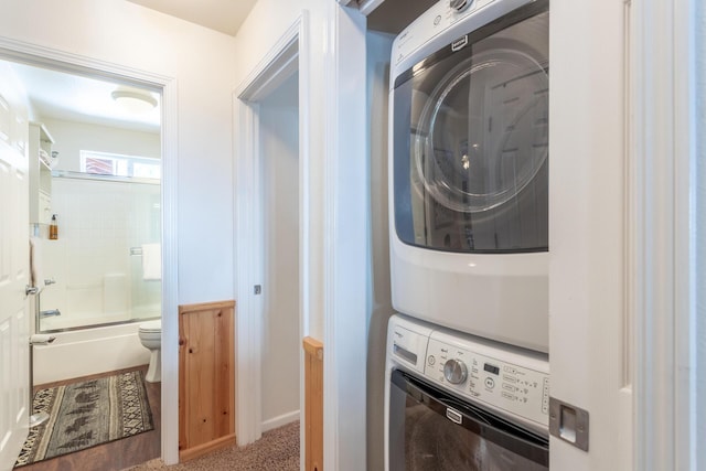 laundry room featuring carpet flooring, stacked washing maching and dryer, and laundry area