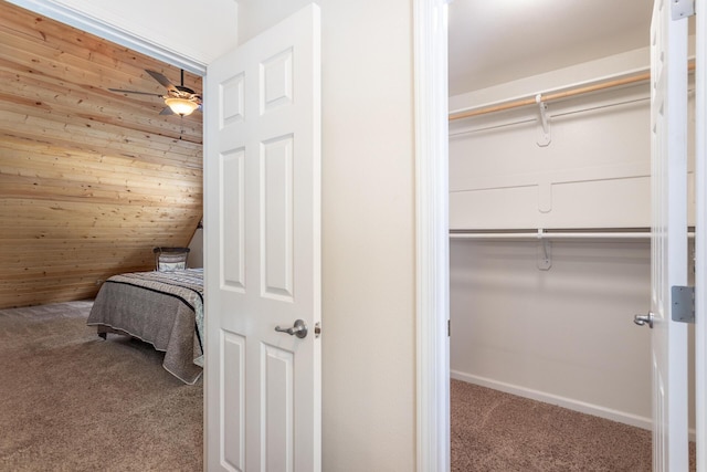 bedroom featuring carpet flooring, wood walls, and a closet