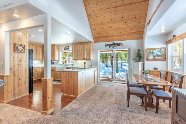 kitchen featuring freestanding refrigerator, a peninsula, backsplash, and light brown cabinets