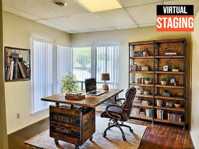 office area featuring wood finished floors, visible vents, baseboards, and a paneled ceiling