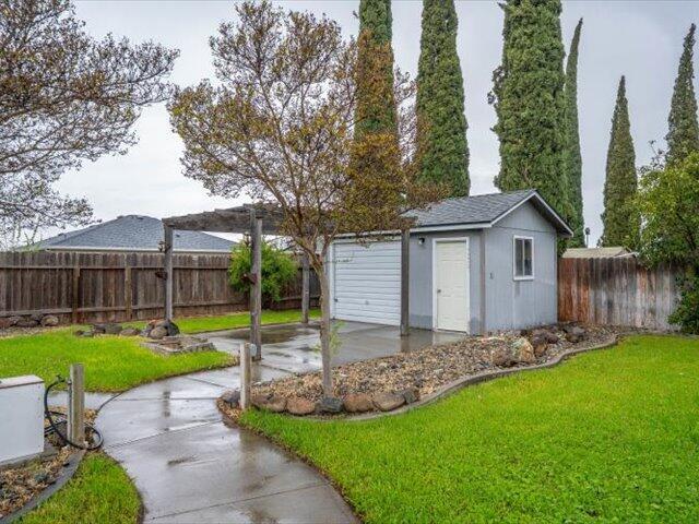 926 Cortina Dr, Orland, CA 95963 - view of yard with an outdoor structure, a fenced backyard, and a patio area