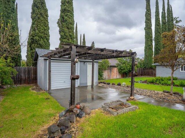 926 Cortina Dr, Orland, CA 95963 - view of outbuilding with a pergola, a fenced backyard, and a garage